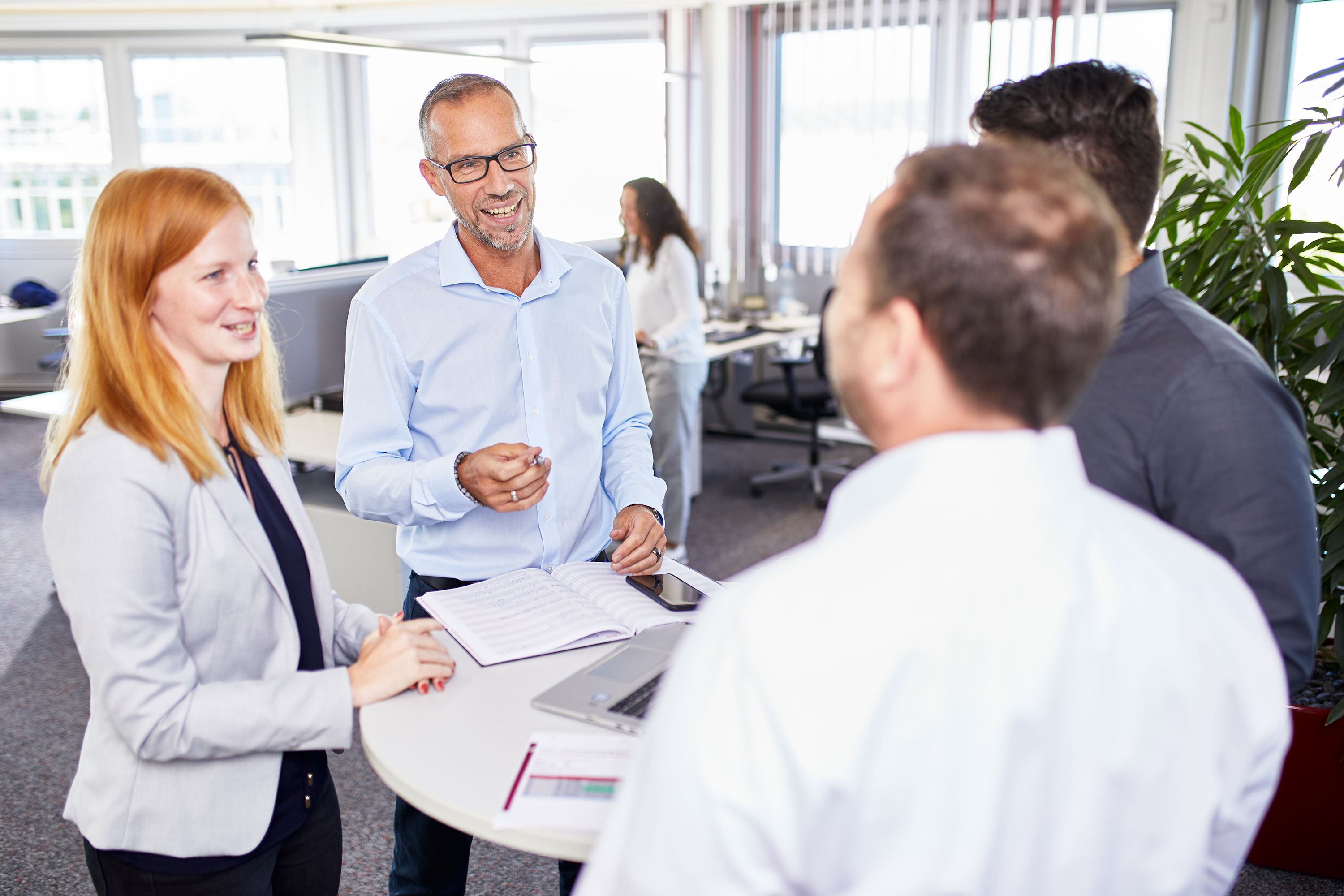 Besprechung im Büro Gruppe steht um runden Tisch